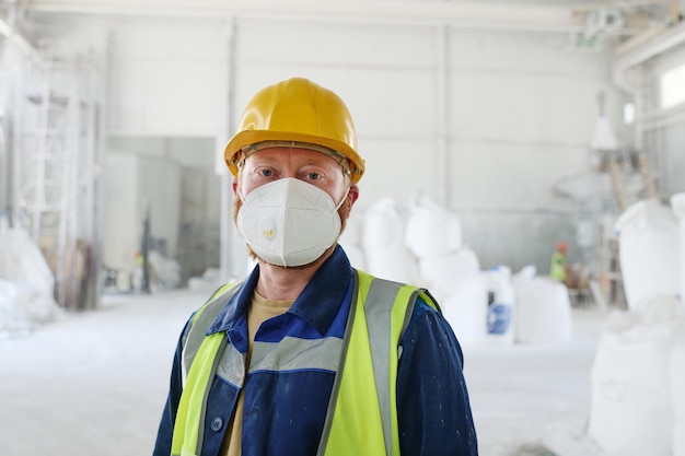 Foto trabajador de fábrica moderna o almacén de distribución que usa respirador