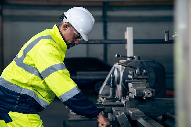 Trabajador de fábrica o ingeniero hace trabajo de máquina en taller de fabricación experto