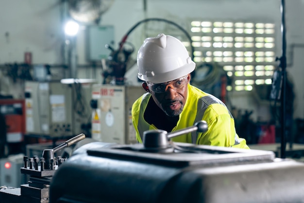 Trabajador de fábrica o ingeniero hace trabajo de máquina en taller de fabricación experto