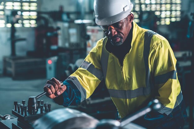 Trabajador de fábrica o ingeniero hace trabajo de máquina en taller de fabricación experto