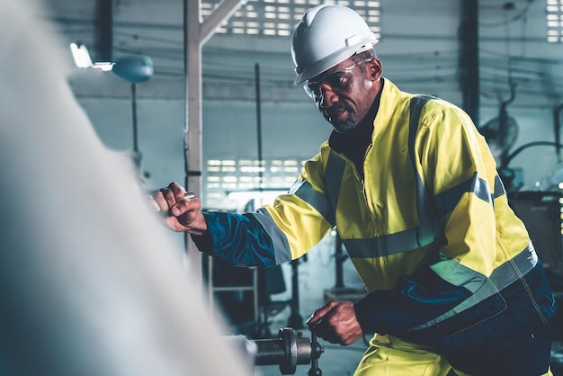 Trabajador de fábrica o ingeniero hace trabajo de máquina en taller de fabricación experto