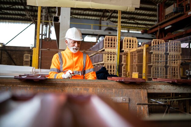 Trabajador de fábrica sosteniendo mosaicos en la sala de producción de fabricación