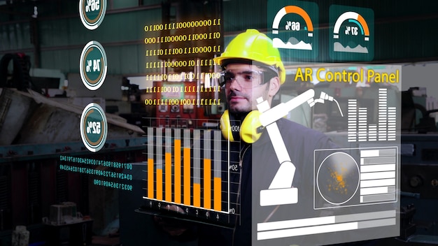 El trabajador de la fábrica utiliza un dispositivo de pantalla holográfica futura para controlar la máquina de fabricación en la fábrica