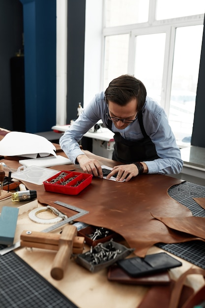 Trabajador de la fabricación de cuero calificado cortando algunas muestras.