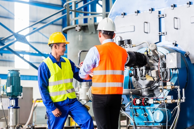 Foto trabajador y gerente de fábrica industrial discutiendo la aceptación de la máquina