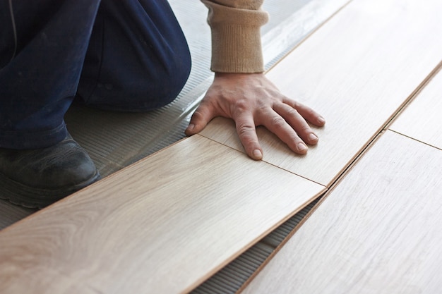 Trabajador hace marcado para colocar pisos laminados