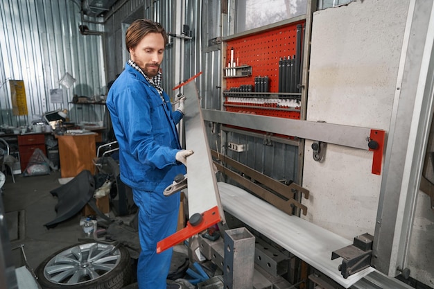 Foto trabajador con herramienta especial para reparación de automóviles