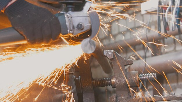 Trabajador de herrero en el detalle de la fabricación de forn con sierra circular