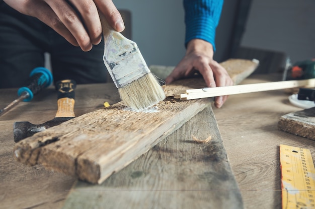 Trabajador hombre mano cepillo pintar madera en mesa