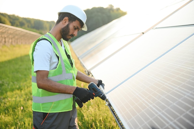 Un trabajador indio está instalando paneles solares en un campo