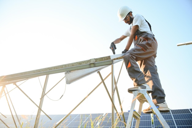 Un trabajador indio instala paneles solares El concepto de energía renovable