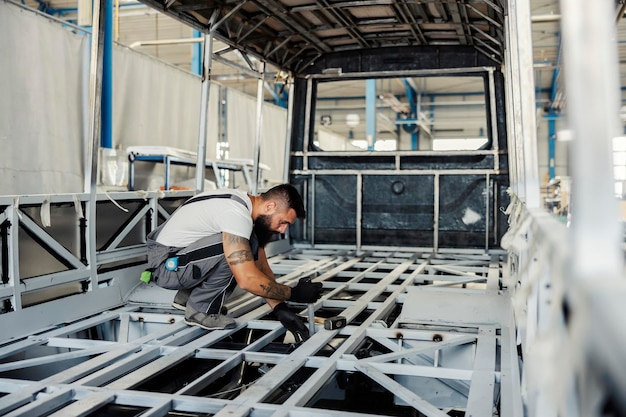 Un trabajador de la industria que construye un autobús en el taller