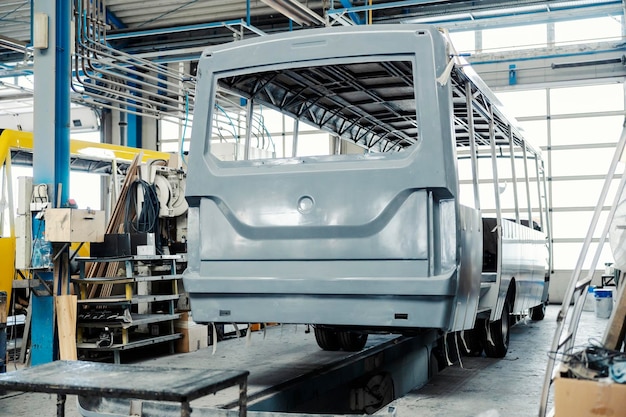 Un trabajador de la industria revisando la construcción de autobuses en la fábrica de producción de vehículos