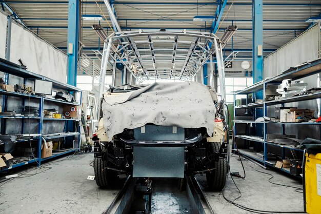 Un trabajador de la industria revisando la construcción de autobuses en la fábrica de producción de vehículos