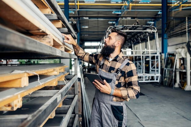 Un trabajador de la industria revisando la construcción de autobuses en la fábrica de producción de vehículos