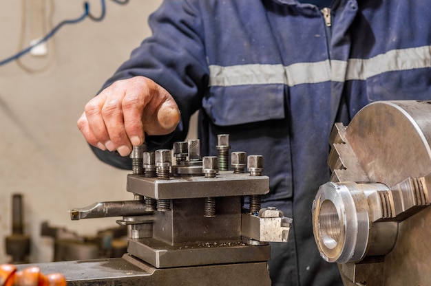 Trabajador industrial pesado operando con maquina de torno