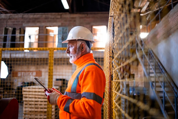 Trabajador industrial de pie en la sala de la fábrica de producción