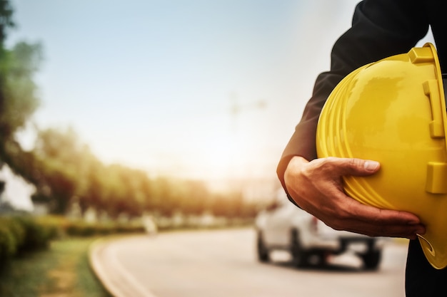 Trabajador ingeniero de arquitectura mantenga casco de seguridad para la construcción