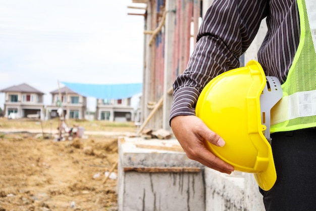 Trabajador de ingeniero de construcción de hombre de negocios asiático con casco protector en el sitio de construcción de viviendas