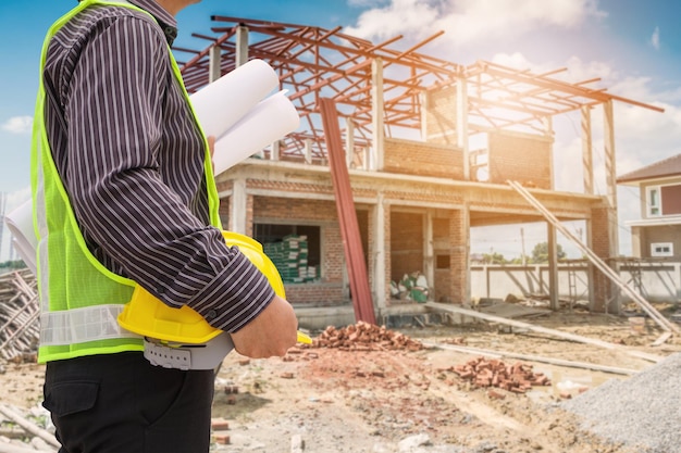 Trabajador de ingeniero de construcción de hombre de negocios asiático en el sitio de construcción de viviendas