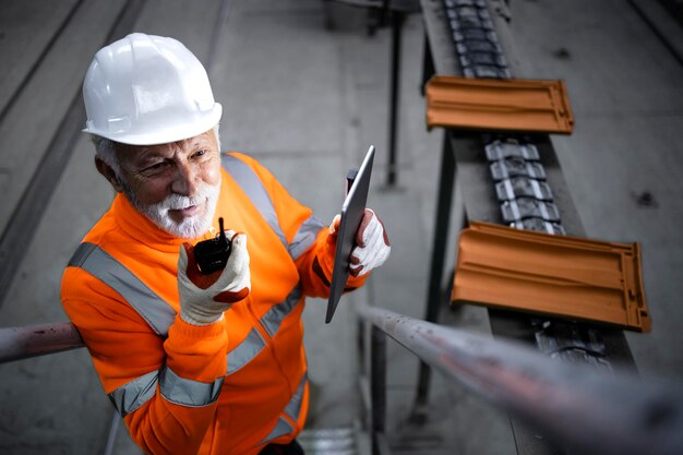 Trabajador ingeniero industrial comprobando la producción en una tableta