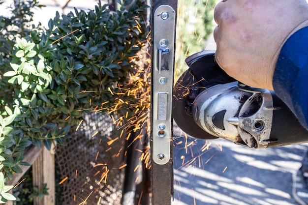 Trabajador instala cerradura de puerta en wicket con molinillo