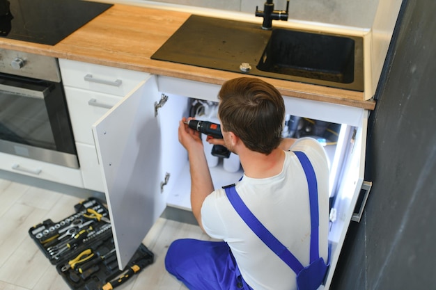 Foto trabajador de instalación de cocina ensamblando muebles