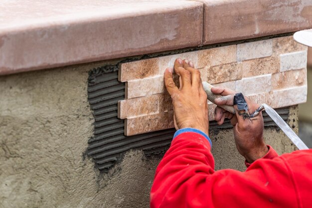 Trabajador instalando azulejos en el sitio de construcción