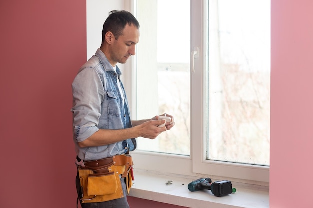 El trabajador instalando y revisando la ventana de la casa.