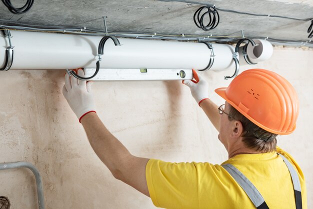 Trabajador instalando un sistema de ventilación en el apartamento