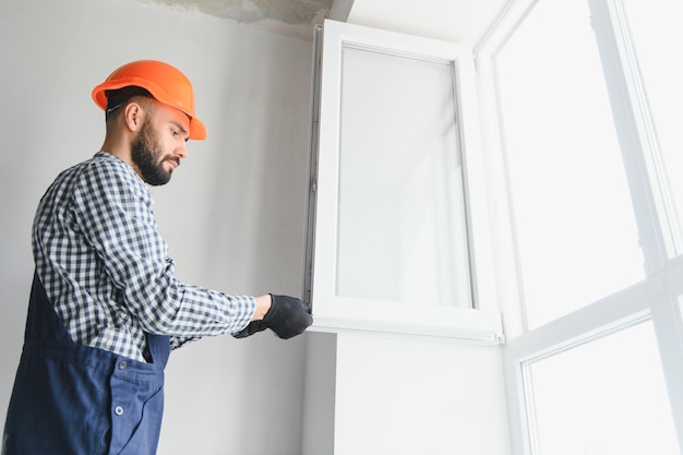 Trabajador instalando ventanas de plástico en interiores