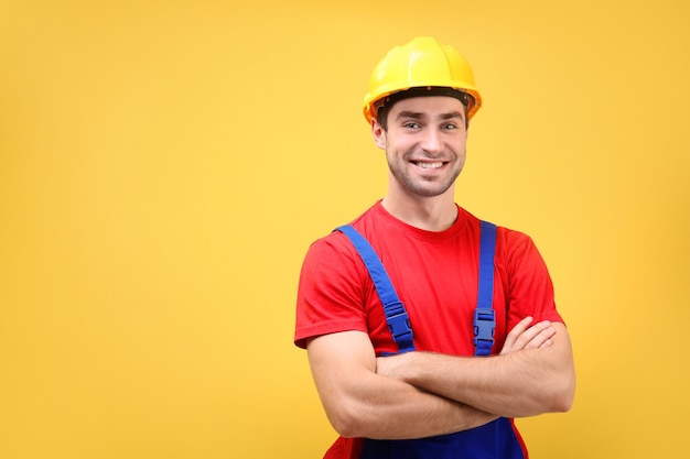 Trabajador joven guapo en pared amarilla