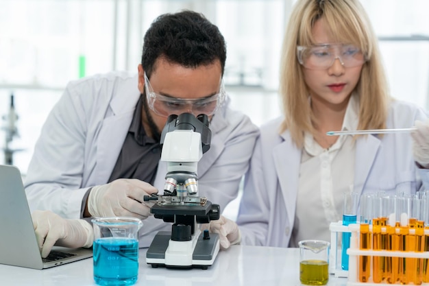 Trabajador de laboratorio con lupa en microscopio