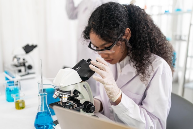 Trabajador de laboratorio con lupa en microscopio