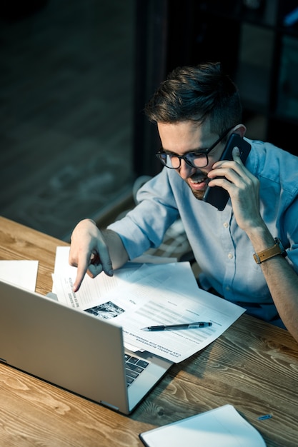 Trabajador con laptop con llamada