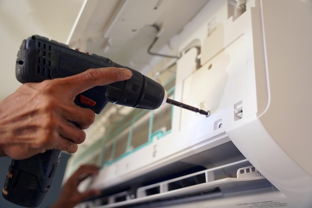 El trabajador limpia y repara el aire acondicionado para asegurarse de que funcione correctamente