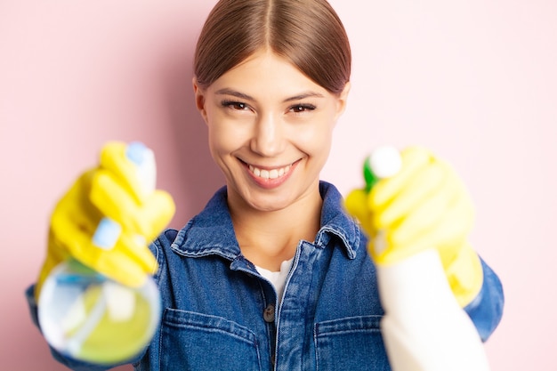 Trabajador de limpieza con mono, guantes amarillos y productos de limpieza