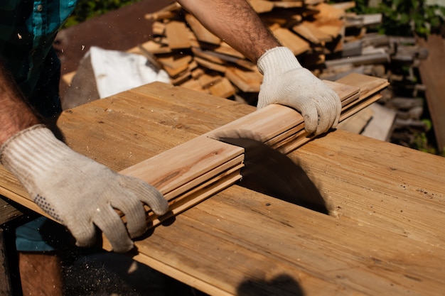 Trabajador de la madera cortando tablones de madera, se centran en la sierra