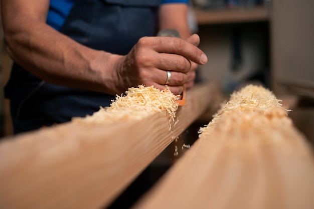 Foto trabajador de la madera en su taller trabajando con herramientas y equipos.