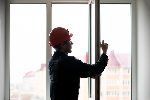 Un trabajador de mantenimiento profesional instala y ajusta la ventana de la casa