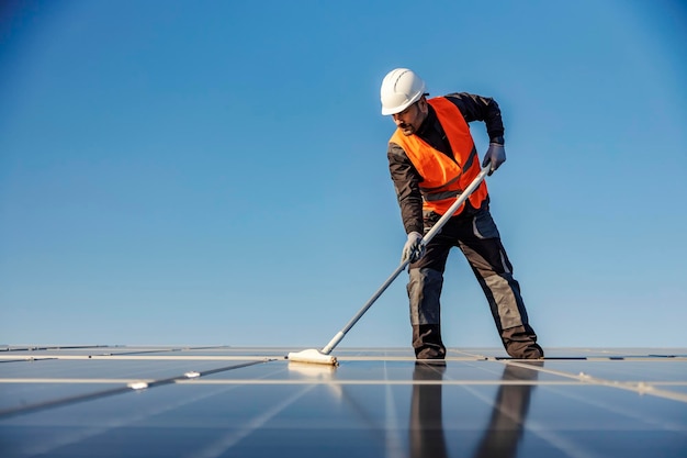 Un trabajador mantiene el panel solar en el techo.