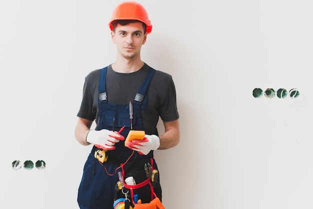 Trabajador manual con herramientas en la pared