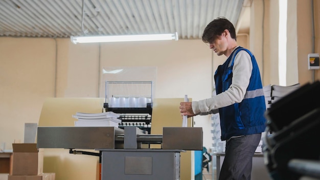 Trabajador y máquina de impresión, industria del polígrafo - primer plano, telefoto