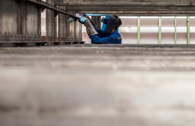 Trabajador con máscara protectora de metal de soldadura