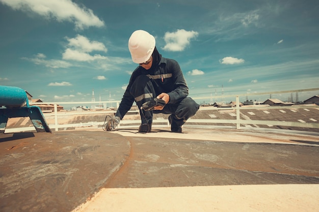 El trabajador masculino es para la inspección de la parte superior de la placa del techo del espesor ultrasónico del tanque de almacenamiento