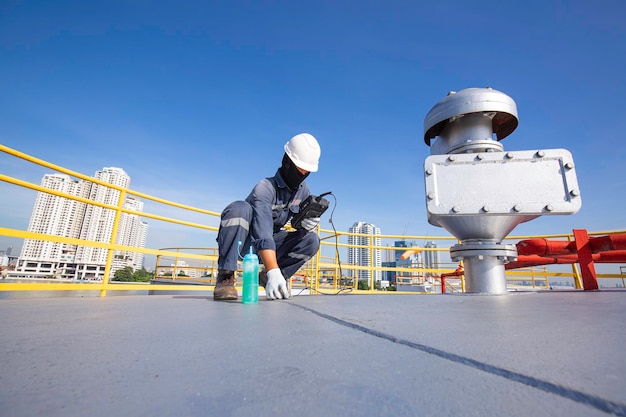 El trabajador masculino es para la inspección de la parte superior de la placa del techo del espesor ultrasónico del tanque de almacenamiento