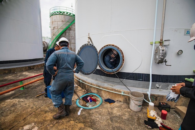 Trabajador masculino en el espacio confinado del área de interfaz de aceite químico de carbono del tanque