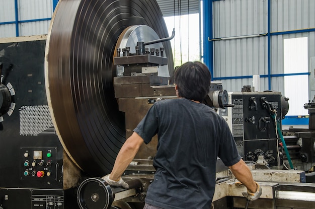 Trabajador masculino está trabajando en una fresadora CNC en la industria del metal.