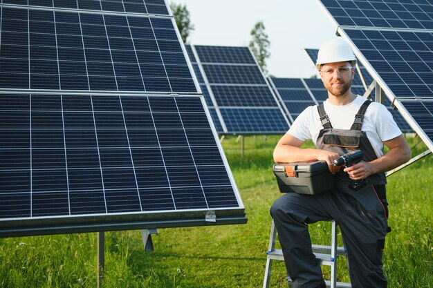 Trabajador masculino en uniforme al aire libre con baterías solares en un día soleado