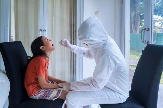 Trabajador médico haciendo una prueba de hisopo a una niña